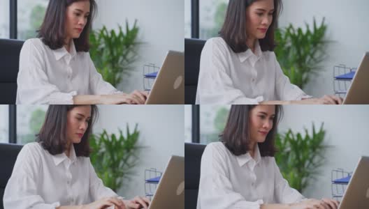 亚洲年轻女商人工作在一个新的正常的生活方式概念的电脑在办公室。女性经理在公司办公室单独使用笔记本电脑发送文件。高清在线视频素材下载