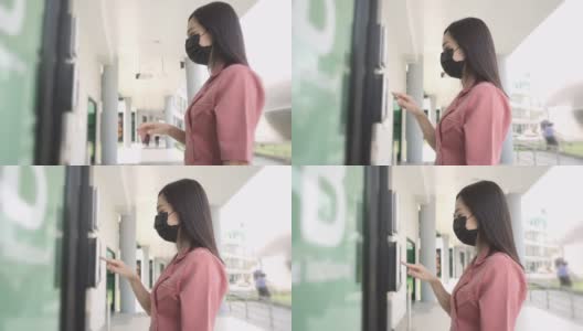 美丽的亚洲女人戴着防护面罩通过手指扫描开门和进入办公室高清在线视频素材下载