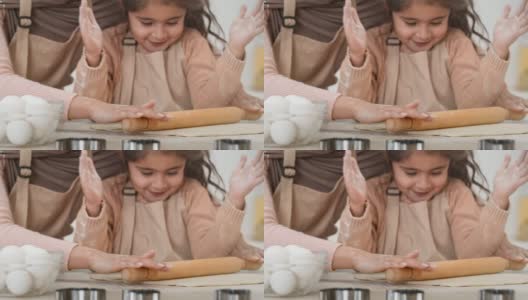 阿拉伯小女孩和妈妈在室内擀面团烘焙糕点高清在线视频素材下载