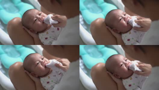 亚洲母亲用抹布清洁婴儿的嘴高清在线视频素材下载