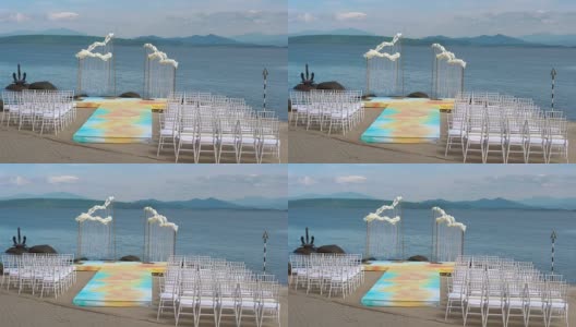 海边的婚礼拱门，前面是一排排的椅子。高清在线视频素材下载