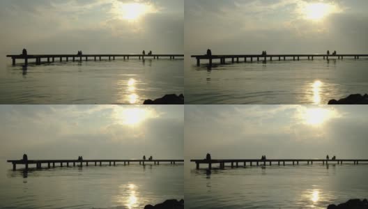 情侣们在码头上看日落。高清在线视频素材下载