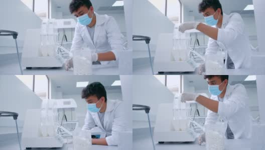 拉丁美洲的一名男学生戴着防护手套和口罩在科学实验室的机器上添加样本高清在线视频素材下载