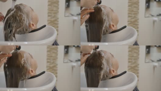 理发师用自来水把少女头上的洗发水冲洗掉高清在线视频素材下载
