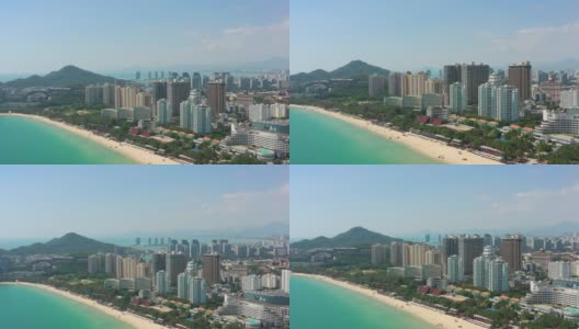 阳光明媚的三亚著名的大东海拥挤的海滩湾空中全景4k海南中国高清在线视频素材下载