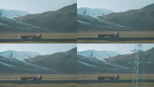 慢镜头:在一个阳光明媚的日子里，一辆挂着空拖车的卡车在乡间行驶。高清在线视频素材下载