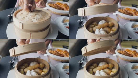 年轻女子打开篮子里的饺子放在桌上点心，传统的中国饺子在传统的木篮子里高清在线视频素材下载