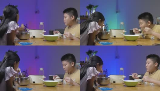 快乐的亚洲儿童享受晚餐涮涮锅或素喜烧在家里，led灯光背景。高清在线视频素材下载
