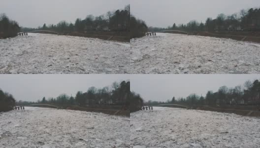 巨大的冰块漂流在拉脱维亚的食人河。空中龙拍摄雪城日。春天这条河上的交通堵塞。一大群移动的冰块高清在线视频素材下载