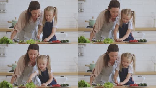 女儿学着做饭，帮妈妈切蔬菜沙拉高清在线视频素材下载