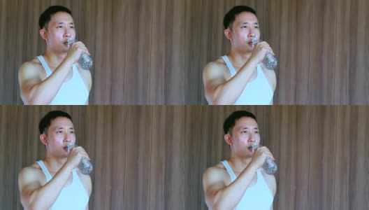 亚洲男人在去健身房后喝水，干渴和运动后疲惫高清在线视频素材下载