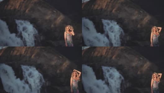 美丽性感的女孩在一个瀑布背景下摆姿势有一个好心情高清在线视频素材下载