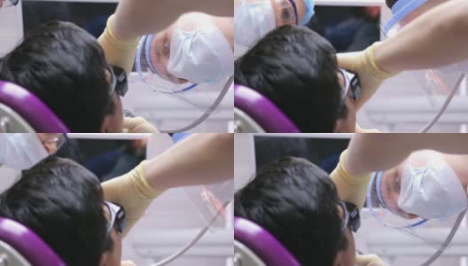 男牙医在一个躺在椅子上的病人身上为清除龋齿而工作高清在线视频素材下载