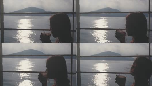 一名年轻女子坐在货轮的长椅上，用纸杯喝茶，眺望着大海。1920 x1080高清在线视频素材下载