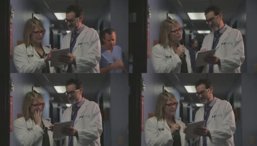 在繁忙的诊所或医院里，两名医生在平板电脑上讨论一个病例高清在线视频素材下载