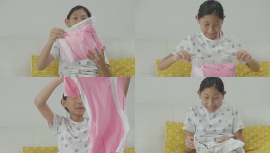 快乐亚洲女孩收到粉色泳衣从网上购物，生活理念。高清在线视频素材下载