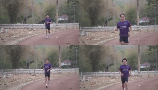 一名亚洲男子在户外运动场上的跑道上跑步。高清在线视频素材下载