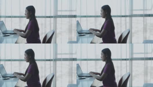 年轻女子在家办公用她的电脑和桌子高清在线视频素材下载