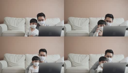 亚洲家庭的商人和男孩在家工作。父子俩戴着健康防护口罩在网上开会，同时被隔离在家。呆在家里。高清在线视频素材下载