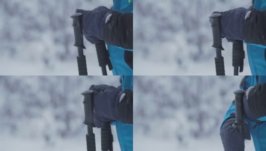滑雪者穿着暖和的夹克，戴着手套，拿着黑色的滑雪杆高清在线视频素材下载