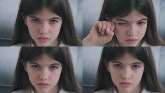 一个忧郁美丽的女孩的肖像，蓝色的眼睛和眼泪在她的脸颊上，少女哭泣高清在线视频素材下载