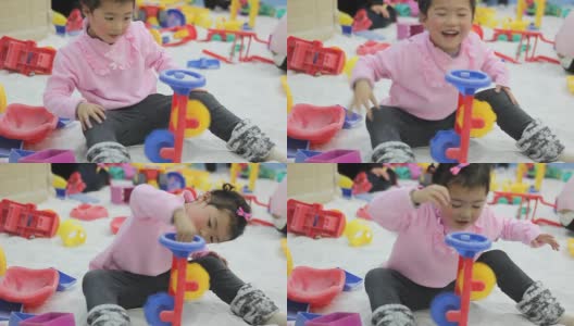 亚洲女孩小孩玩沙漏斗玩具，笑着，浅景深。高清在线视频素材下载