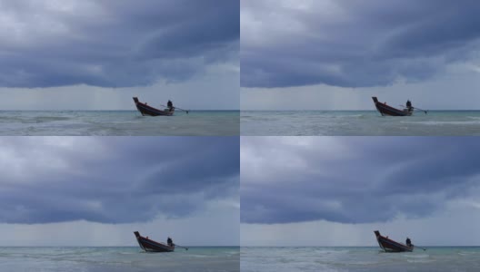 在浅海中，长尾船在海滩附近摆动。背景是泰国的风暴云高清在线视频素材下载