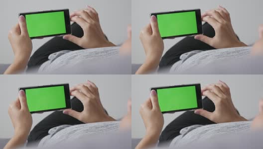 女性放松在床上与绿色屏幕显示智能手机平移高清在线视频素材下载