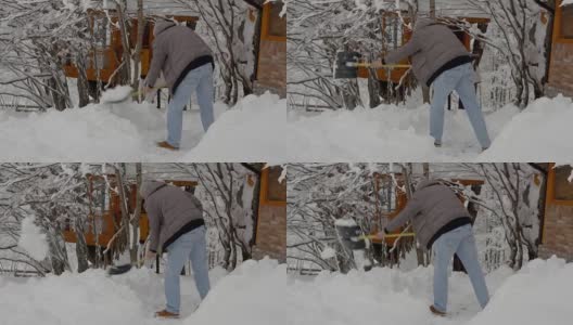 在一个大雪纷飞的寒冷早晨，一名男子拿着铲子正在清除院子里的积雪，高清在线视频素材下载