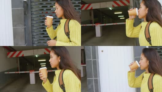 十几岁的女孩一边喝咖啡一边走在人行道上高清在线视频素材下载