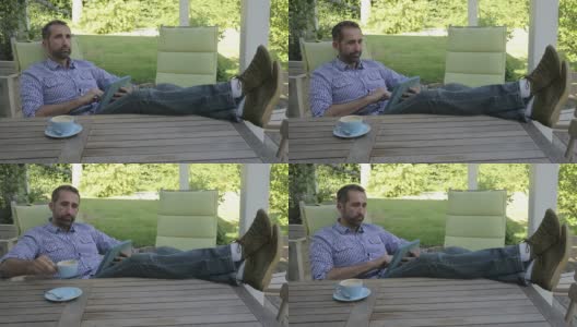 一个男人坐在院子里，拿着他的数码平板电脑高清在线视频素材下载