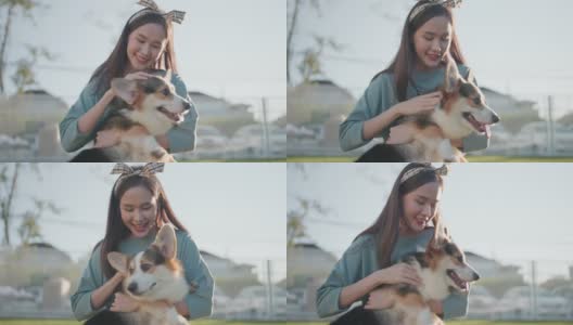 快乐在一起，有吸引力的亚洲女性年轻的成年女性喜欢与可爱的柯基狗玩，日落在室外草地后院高清在线视频素材下载