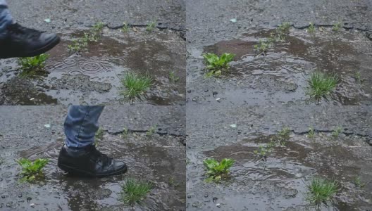 慢镜头:一个水坑的特写镜头，一个穿着黑鞋的男人踩进水坑里高清在线视频素材下载