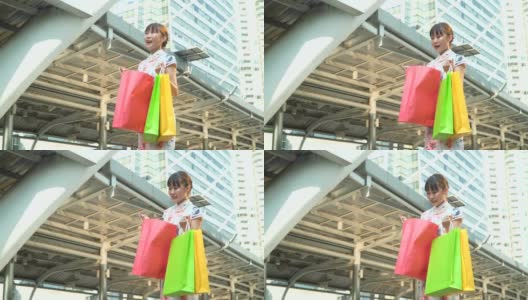 低角度侧视图:美丽的女人正在看购物袋在城市购物后高清在线视频素材下载