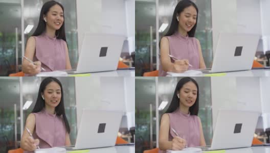 快乐的亚洲女商人与同事视频通话，戴着耳机在现代办公室，快乐，创业，企业家高清在线视频素材下载