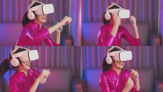 年轻的亚洲女性正在使用虚拟现实耳机。霓虹灯工作室肖像。虚拟现实、模拟、游戏和未来技术的概念。亚洲女人在卧室里玩游戏。高清在线视频素材下载