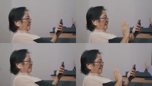 奶奶在家里用智能手机和孙子聊天。高清在线视频素材下载