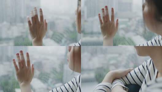 女人的手用雨滴触摸窗户高清在线视频素材下载