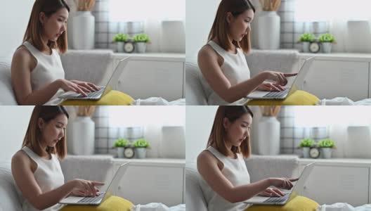 年轻的亚洲女性使用笔记本电脑在家工作高清在线视频素材下载