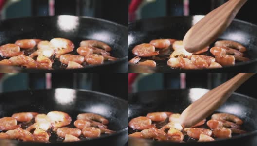用竹铲将虾放入锅中，用慢动作搅拌。高清在线视频素材下载