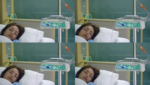 年轻美丽的病人女人睡在医院VIP房间的床上模糊运动输液泵机。高清在线视频素材下载