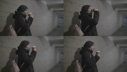 pretty woman drinks coffee in a tunnel, thinks about something someone is waiting for高清在线视频素材下载