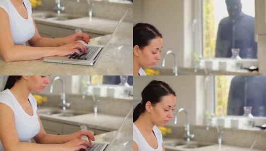 一个女人在笔记本电脑上打字，小偷在里面窥视高清在线视频素材下载