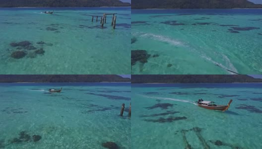 鸟瞰图的热带海滩，长尾船和岩石海岸与清澈的绿松石水在泰国岛，日出海滩，Koh Lipe，萨顿，泰国高清在线视频素材下载