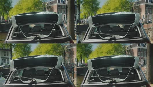 一辆后窗破了的车。是市中心小偷和破坏者的受害者。在阿姆斯特丹市中心的运河岸边高清在线视频素材下载