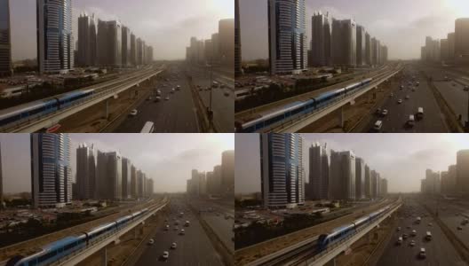 火车在阿联酋迪拜摩天大楼之间的高速公路上越过高架桥高清在线视频素材下载
