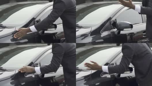 一名男子在擦拭他豪华轿车上的灰尘，对洗车服务不满意高清在线视频素材下载