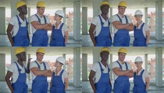 自信的工人和妇女们站在一起，穿着工作服，戴着安全帽，对着镜头微笑高清在线视频素材下载