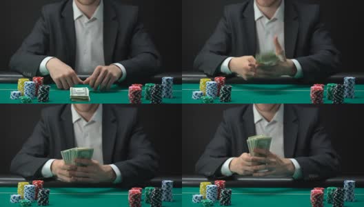 赌场的幸运赢家手里拿着美元钞票，桌上摆着筹码，游戏奖励高清在线视频素材下载