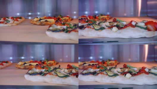 几种不同馅料的披萨在烤箱里烤熟。特写镜头高清在线视频素材下载